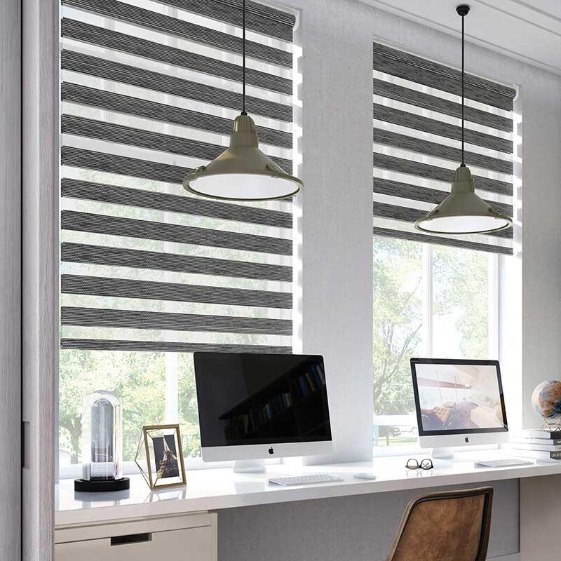 Zebra-/duo-rullgardiner i randigt mörkgrått installerade i kontorsarbetsplats med fönster och skrivbord