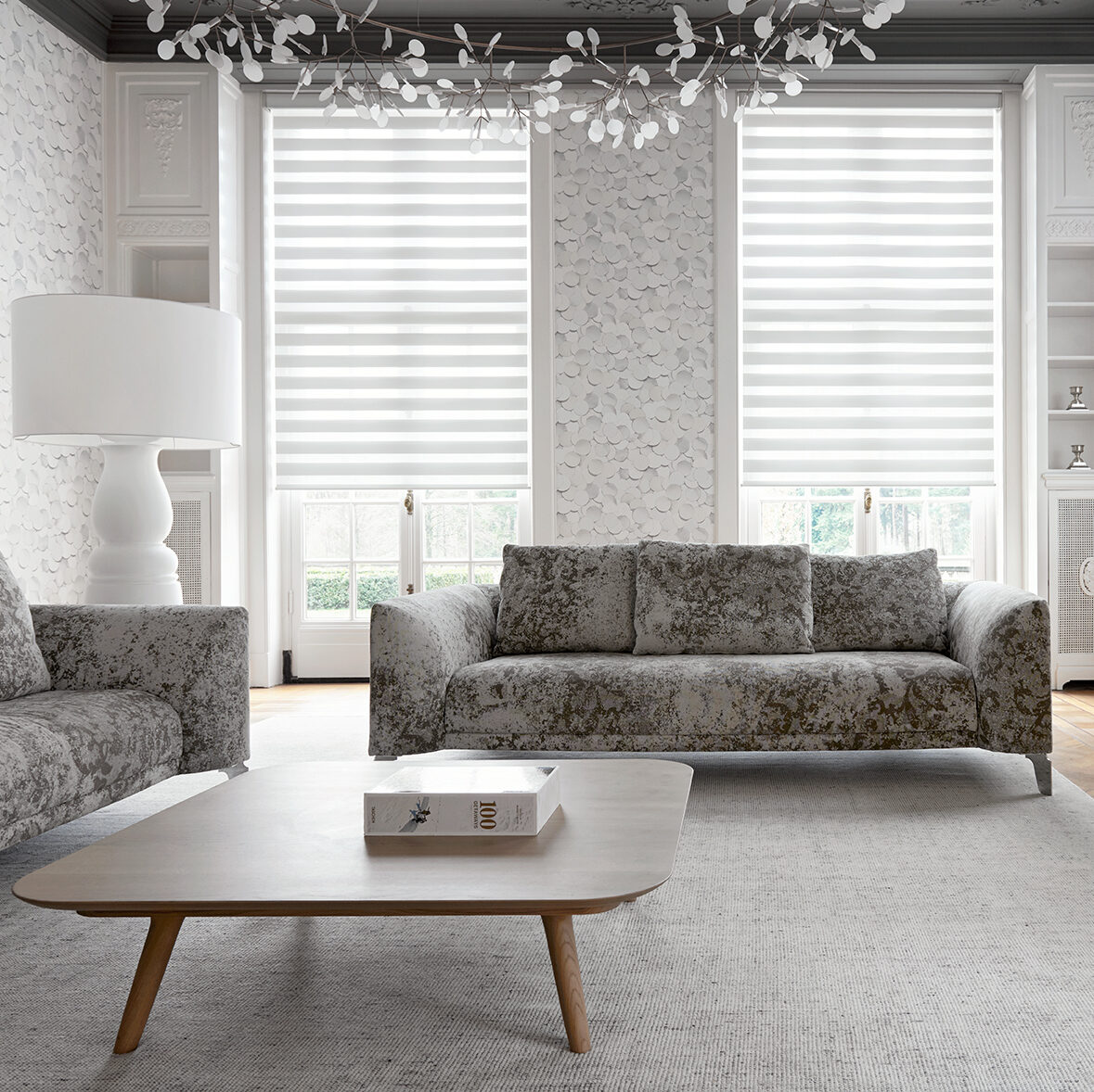 Vision rullgardiner (duo/Zebra) i vitt i elegant vardagsrum med soffa och stora fönsterfickor