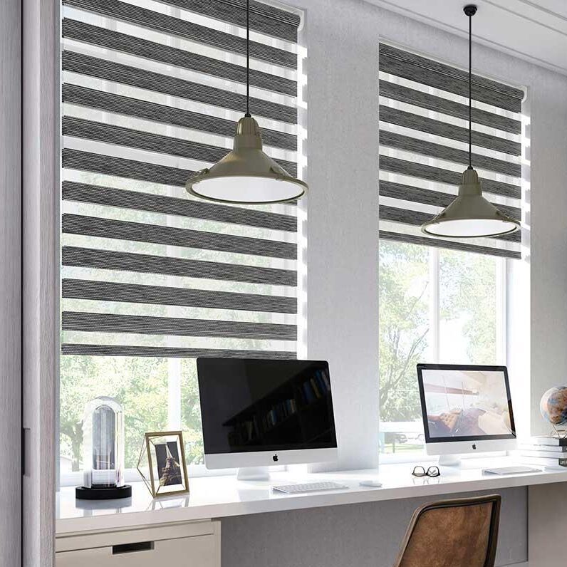 Zebra-/duo-rullgardiner i randigt mörkgrått installerade i kontorsarbetsplats med fönster och skrivbord